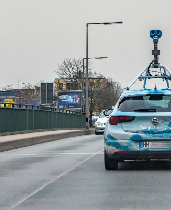 Ein Fahrzeug von Google Street View mit einer aufgebauten Kamera fährt über eine Brücke in Köln-Lövenich.