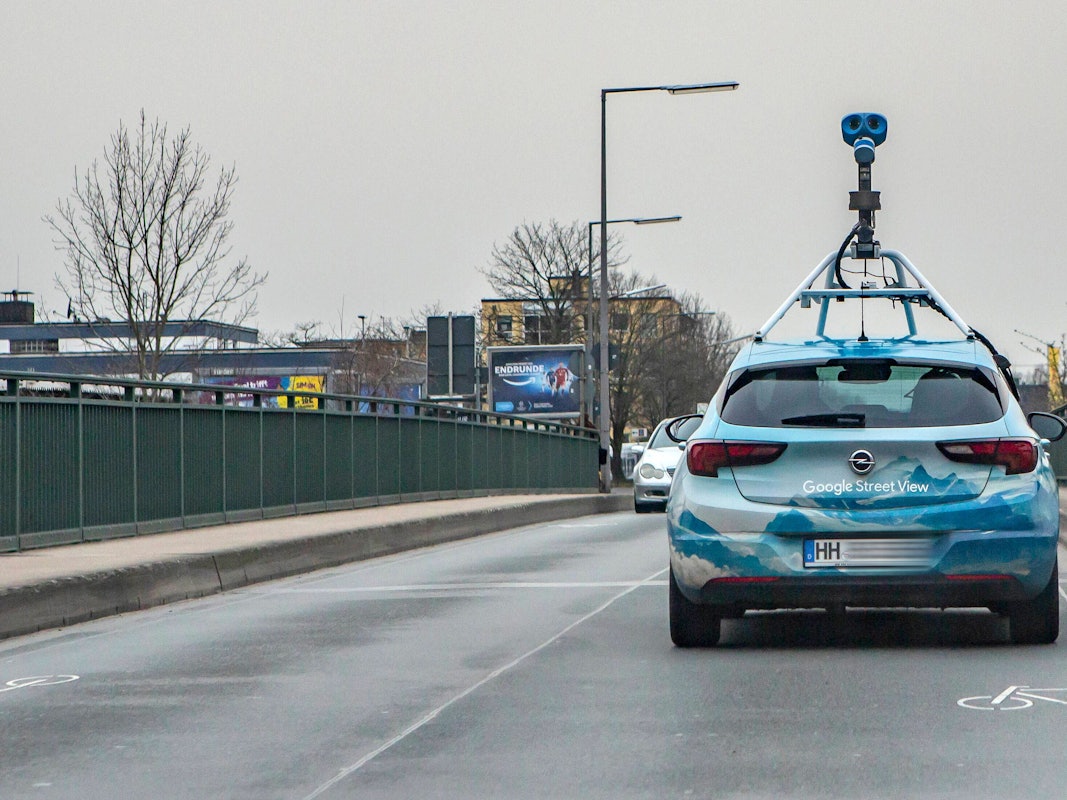 Ein Fahrzeug von Google Street View mit einer aufgebauten Kamera fährt über eine Brücke in Köln-Lövenich.