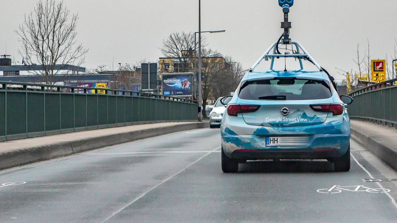 Ein Fahrzeug von Google Street View mit einer aufgebauten Kamera fährt über eine Brücke in Köln-Lövenich.