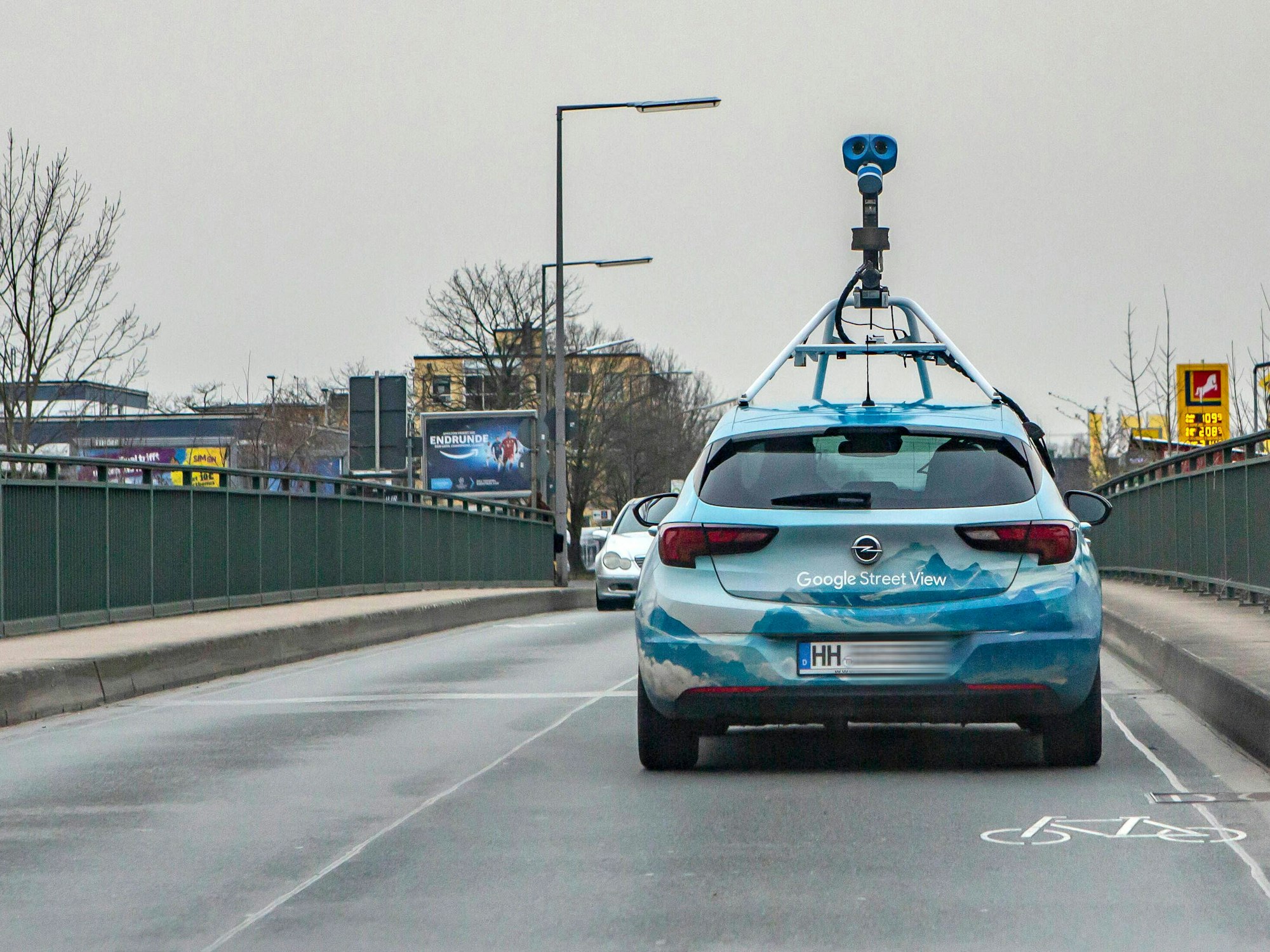 Ein Fahrzeug von Google Street View mit einer aufgebauten Kamera fährt über eine Brücke in Köln-Lövenich.