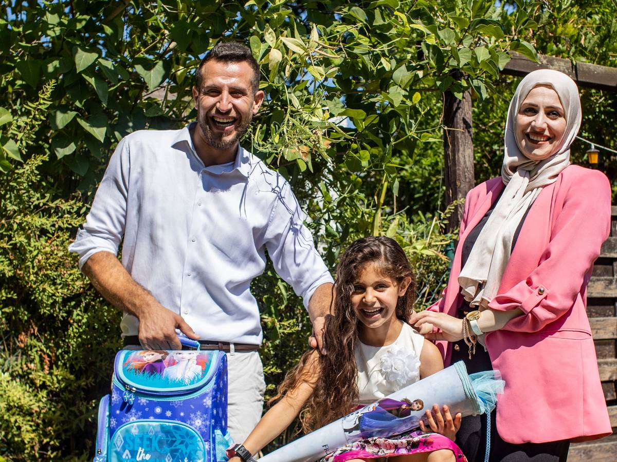 Angela, sechs Jahre alt und frisch eingeschult, strahlt mit Vater Ezzat und Mutter Medea um die Wette.