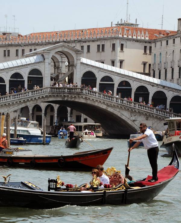 Gondeln, Boote sowie ein Vaporetto fahren auf dem Canale Grande vor der Rialtobrücke in Venedig (Italien). Das Foto wurde im Mai 2011 aufgenommen.
