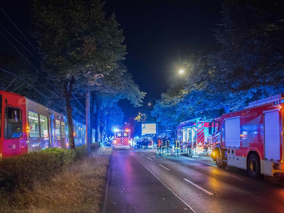 Köln: Feuerwehr und Einsatzkräfte stehen neben einer Straßenbahn, die einen Passanten mitgeschleift hat. Der 55-Jährige blieb ersten Erkenntnissen zufolge mit seinem Rucksack an der Bahn hängen und wurde dann einige Meter mitgezogen.