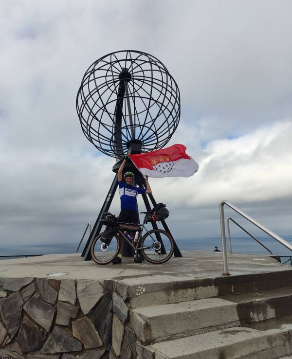 Sebastian Knobloch mit Rad und Köln-Flagge auf der Spenden-Tour