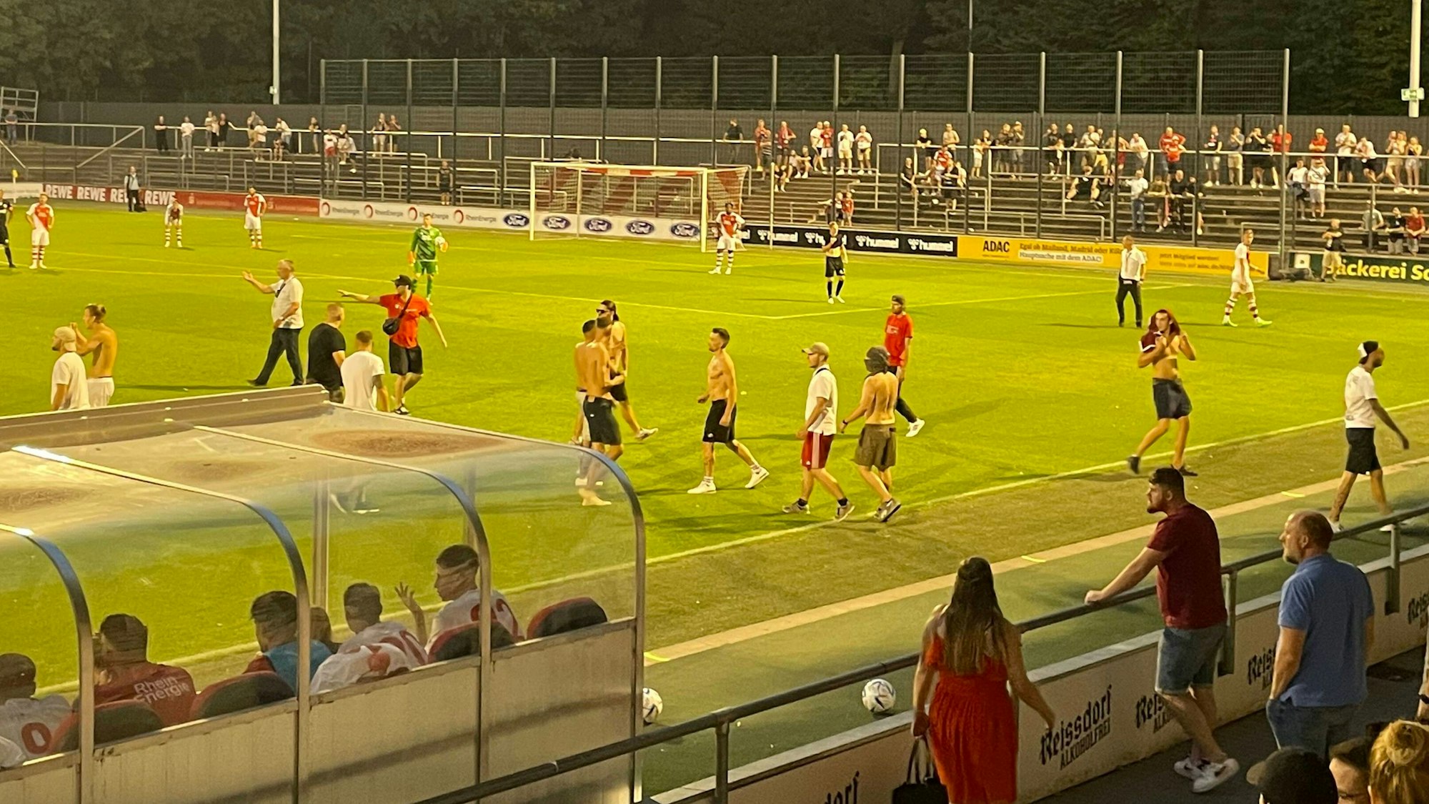 Fans des 1. FC Köln laufen auf den Rasen im Franz-Kremer-Stadion.