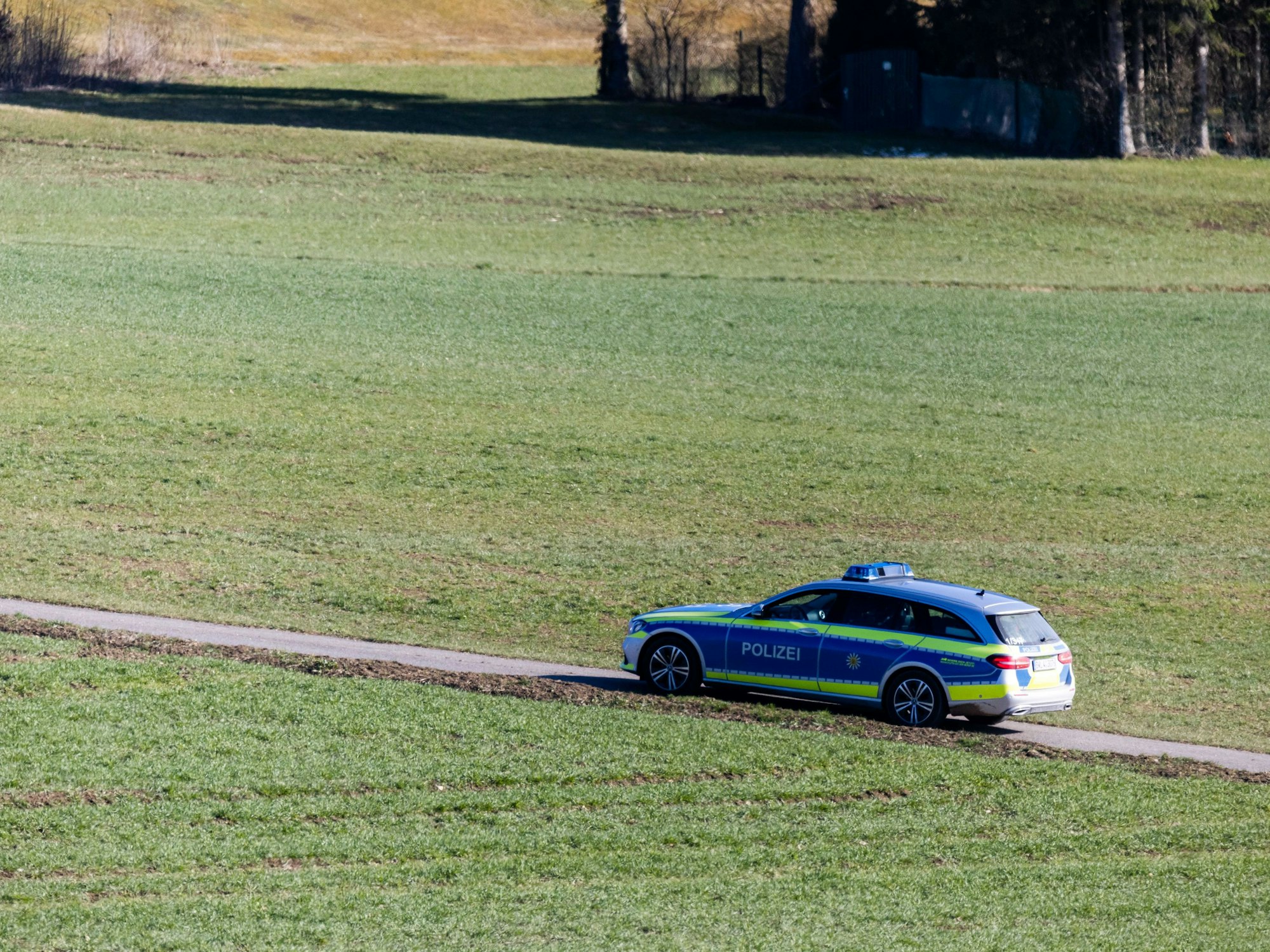 Ein Polizeifahrzeug fährt über einen Feldweg in Baden-Württemberg.