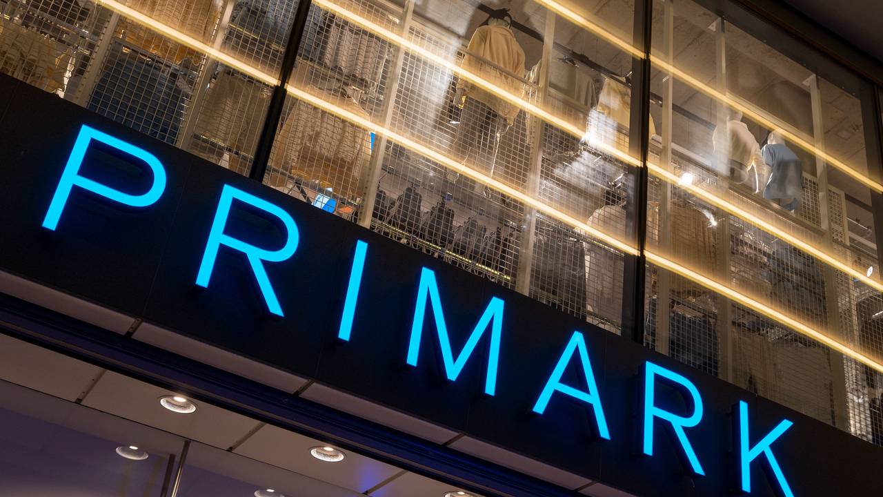 Das Logo des Bekleidungsgeschäfts Primark leuchtet am Abend an der Fassade.