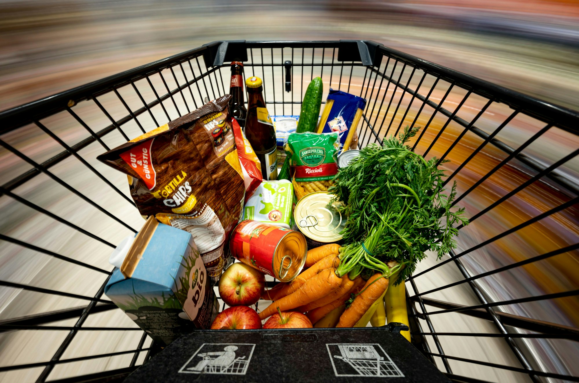 Ein Einkaufswagen gefüllt mit Lebensmitteln wie Obst und Gemüse