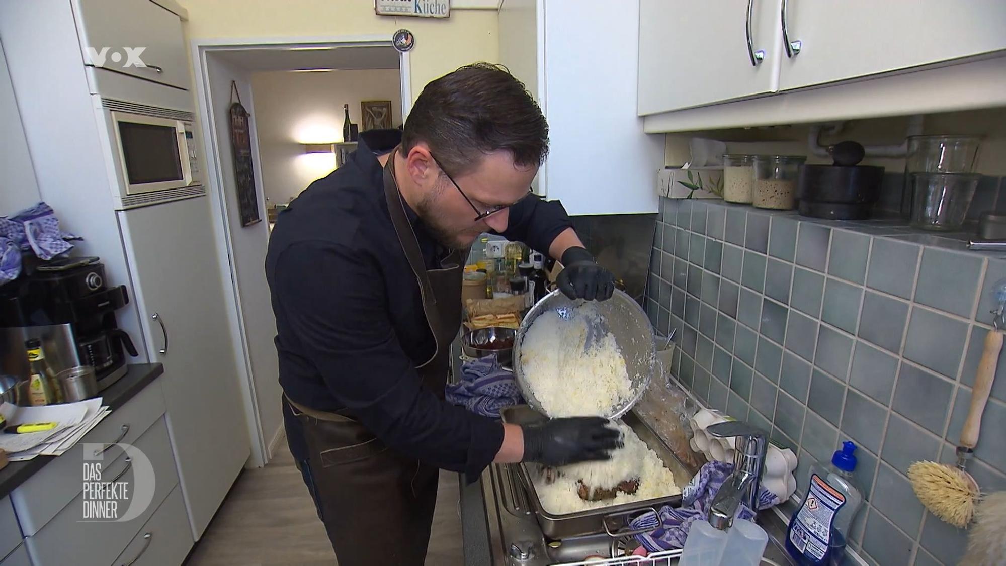 Gastgeber Marius steht am zweiten Tag von „Das perfekte Dinner“ in Lüneburg (TV-Ausstrahlung: 16. August 2022) in seiner Küche.