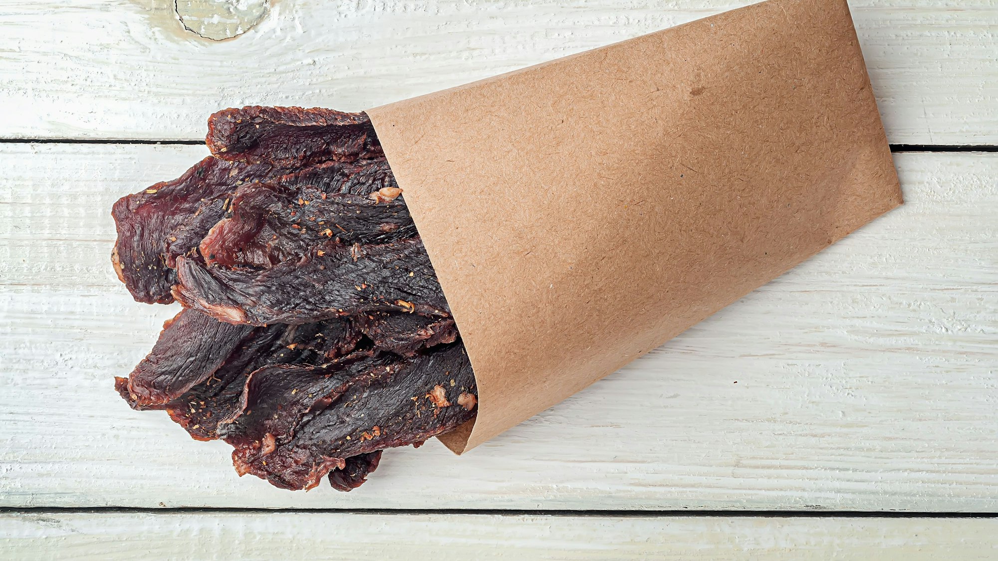 Beef Jerky in einer Papiertüte auf einem Holztisch