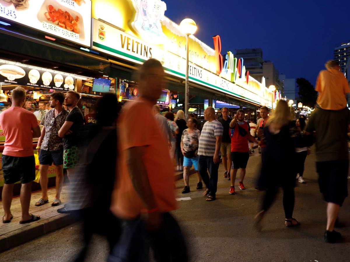 Menschen gehen an der Bar Bamboleo in der Bierstraße am Ballermann vorbei.