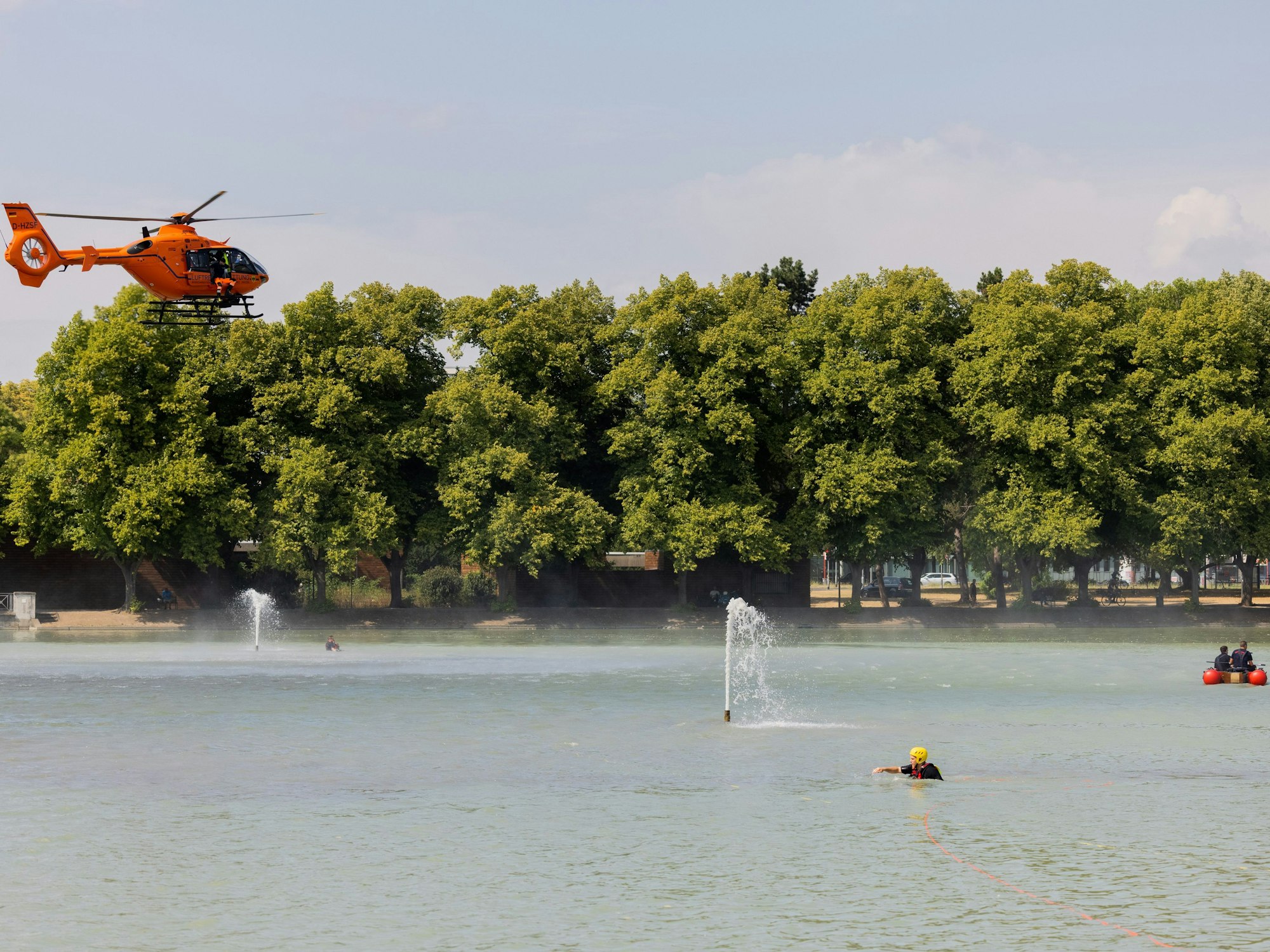 Einsatzkräfte suchen mit Helikopter und Booten nach einer Person, die Zeugen in dem Gewässer am Aachener Weiher gesehen haben wollen.