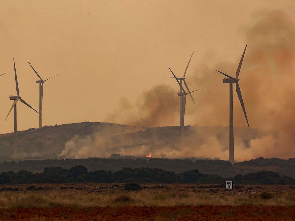Rauch steigt bei Windrädern wegen eines Brandes nahe der Autobahn A23. Bei den verheerenden Waldbränden in der spanischen Urlaubsregion Valencia sind mehrere Passagiere eines Regionalzuges im Gebiet Bejís verletzt worden.