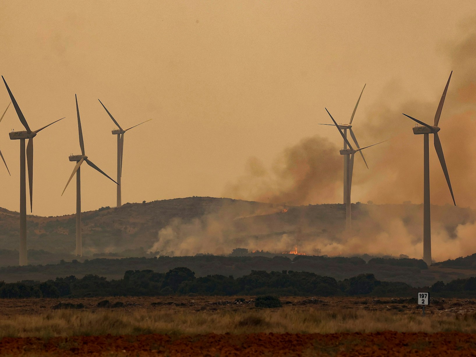 Rauch steigt bei Windrädern wegen eines Brandes nahe der Autobahn A23. Bei den verheerenden Waldbränden in der spanischen Urlaubsregion Valencia sind mehrere Passagiere eines Regionalzuges im Gebiet Bejís verletzt worden.