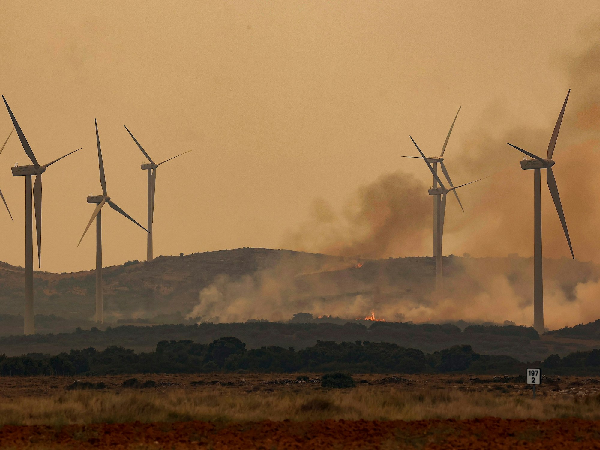 Rauch steigt bei Windrädern wegen eines Brandes nahe der Autobahn A23. Bei den verheerenden Waldbränden in der spanischen Urlaubsregion Valencia sind mehrere Passagiere eines Regionalzuges im Gebiet Bejís verletzt worden.