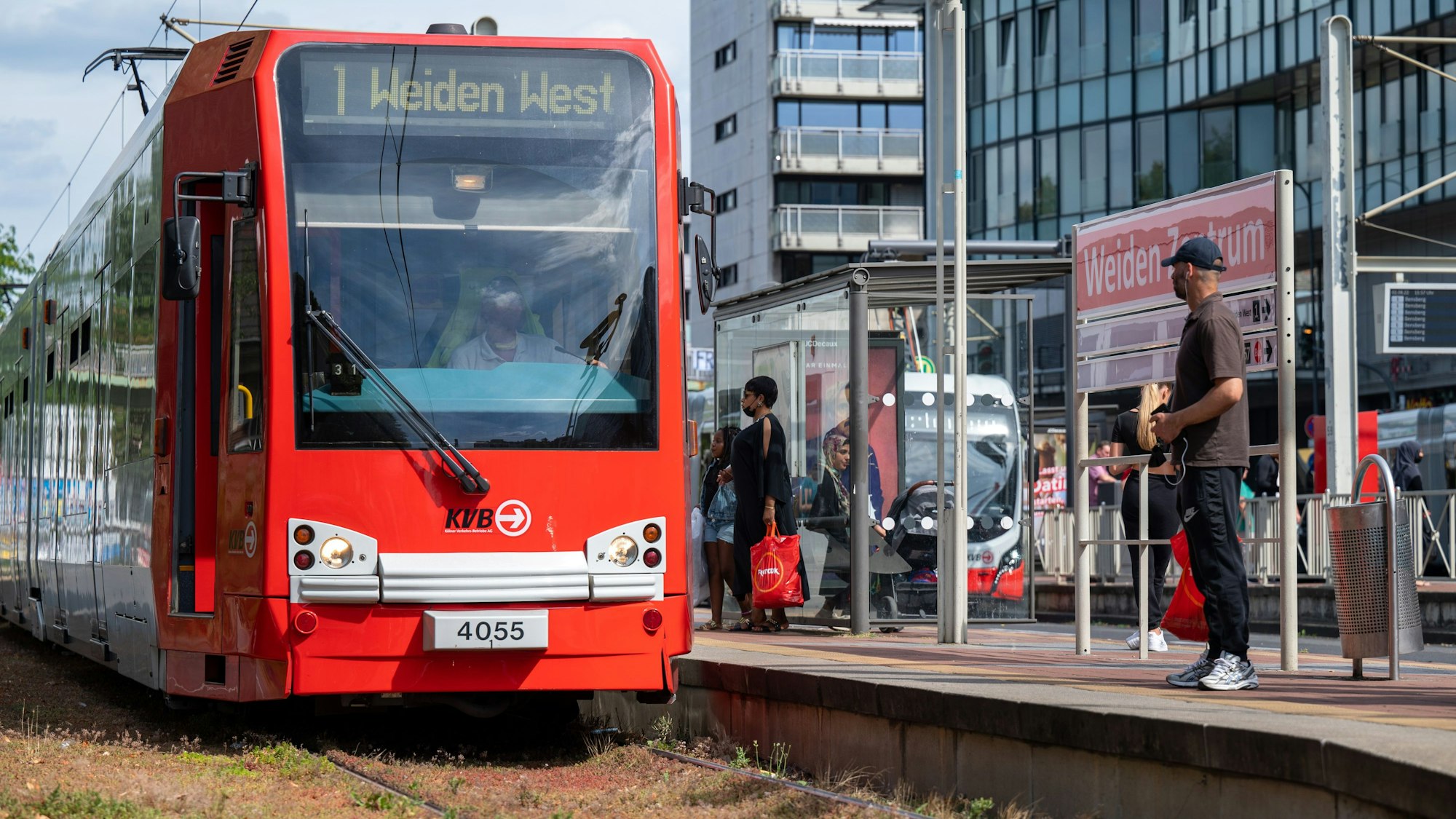 Eine KVB-Bahn der Linie 1 hält an der Haltestelle Weiden Zentrum.