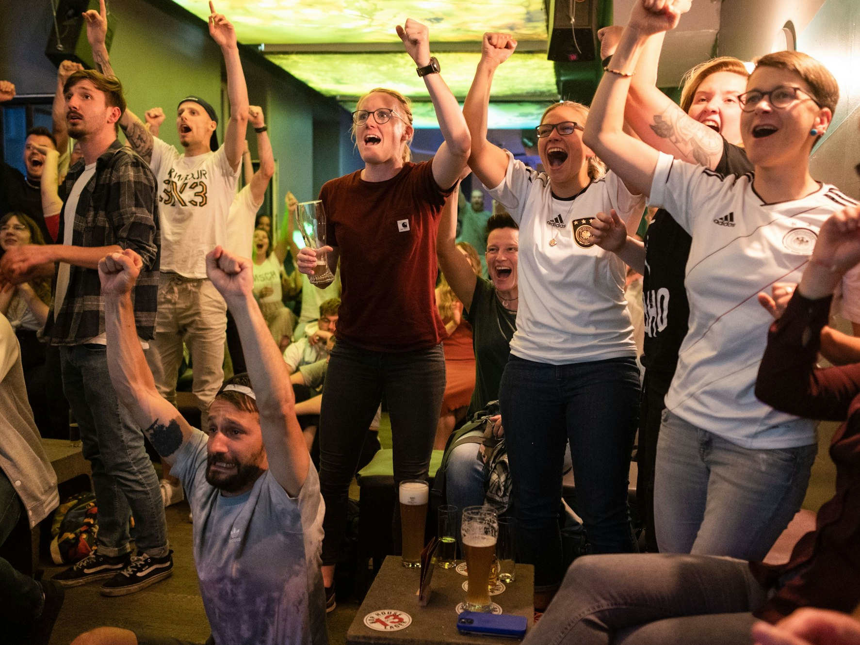 Fußballfans verfolgen eine Partie in einer Kneipe