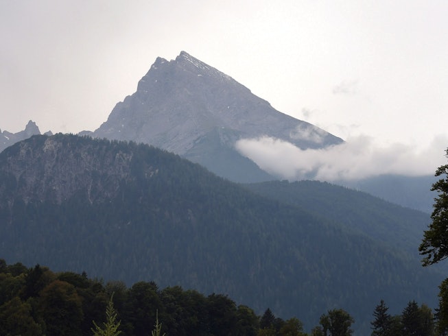 Wolken und Sonne umgeben den Gipfel des Watzmann-Massivs. Er ist der zentrale Gebirgsstock der Berchtesgadener Alpen.
