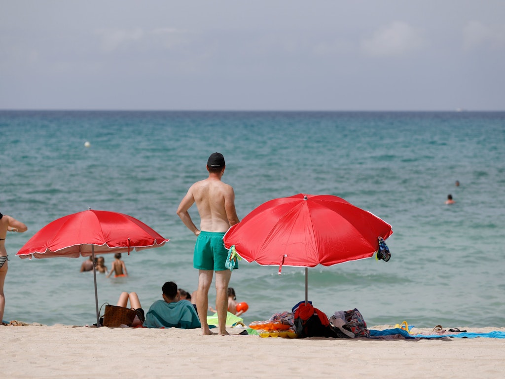 Menschen sonnen sich am Strand von Arenal auf Mallorca. +++ dpa-Bildfunk +++