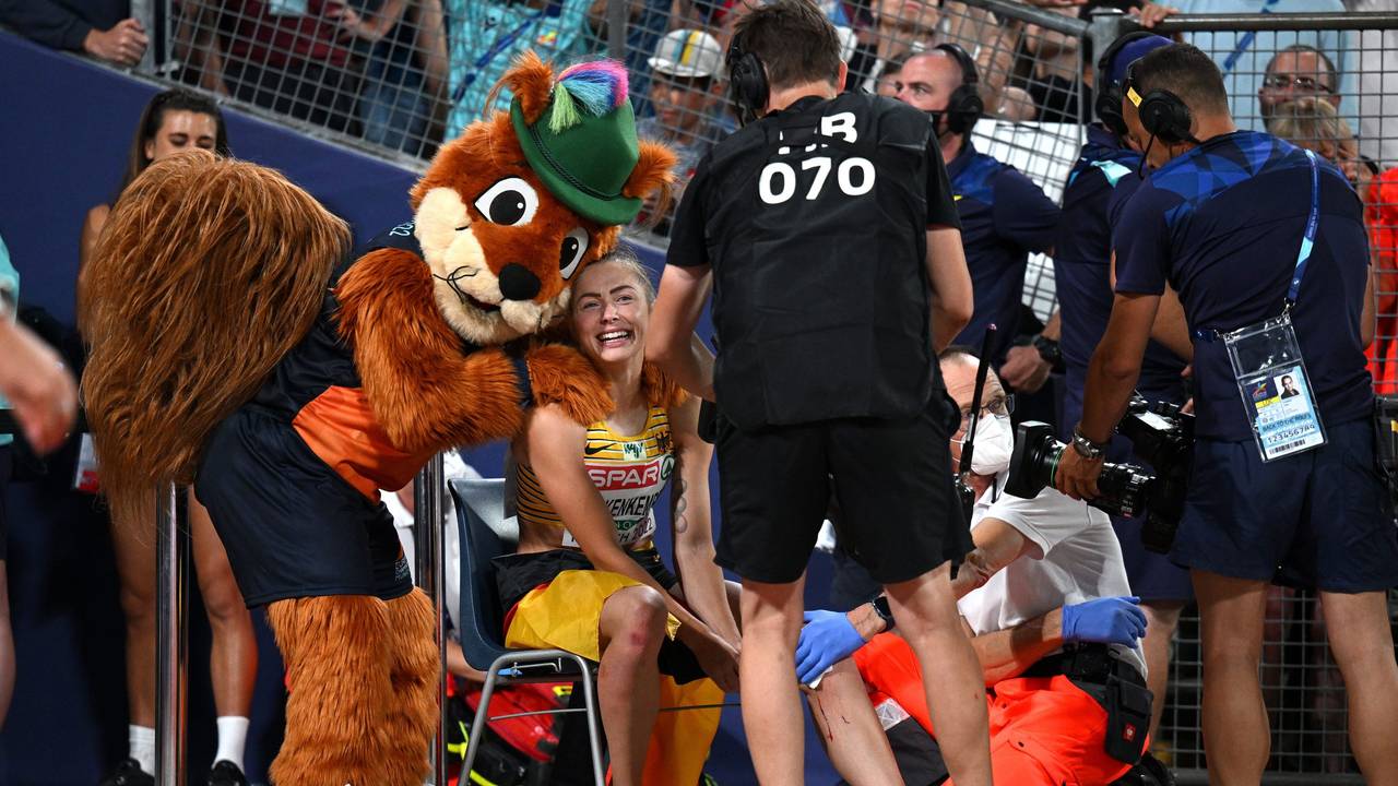 Gina Lückenkemper wird von Maskottchen Gfreidi umarmt und von Sanitätern versorgt.