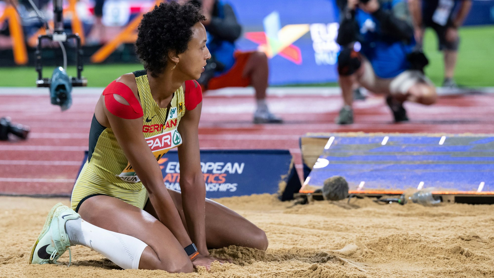 Malaika Mihambo kniet beim Weitsprung-Finale in der Sandgrube. Für Gold reichte es im Wettkampf knapp nicht.
