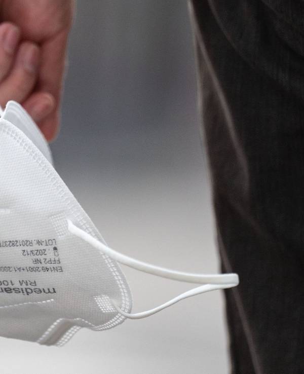 Eine Passantin trägt am 3. August 2022 eine FFP2-Maske in der Hand. NRW hat die bisherigen Corona-Schutzmaßnahmen vorzeitig bis weit in den September hinein verlängert.