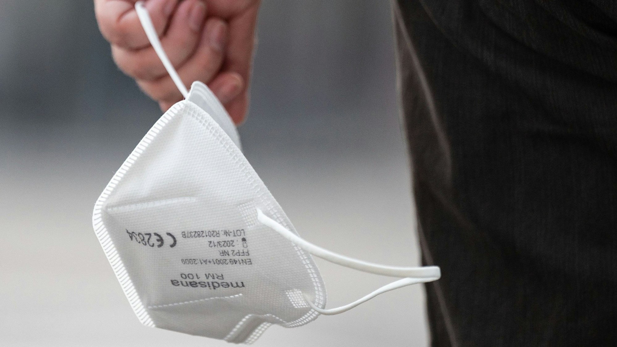 Eine Passantin trägt am 3. August 2022 eine FFP2-Maske in der Hand. NRW hat die bisherigen Corona-Schutzmaßnahmen vorzeitig bis weit in den September hinein verlängert.