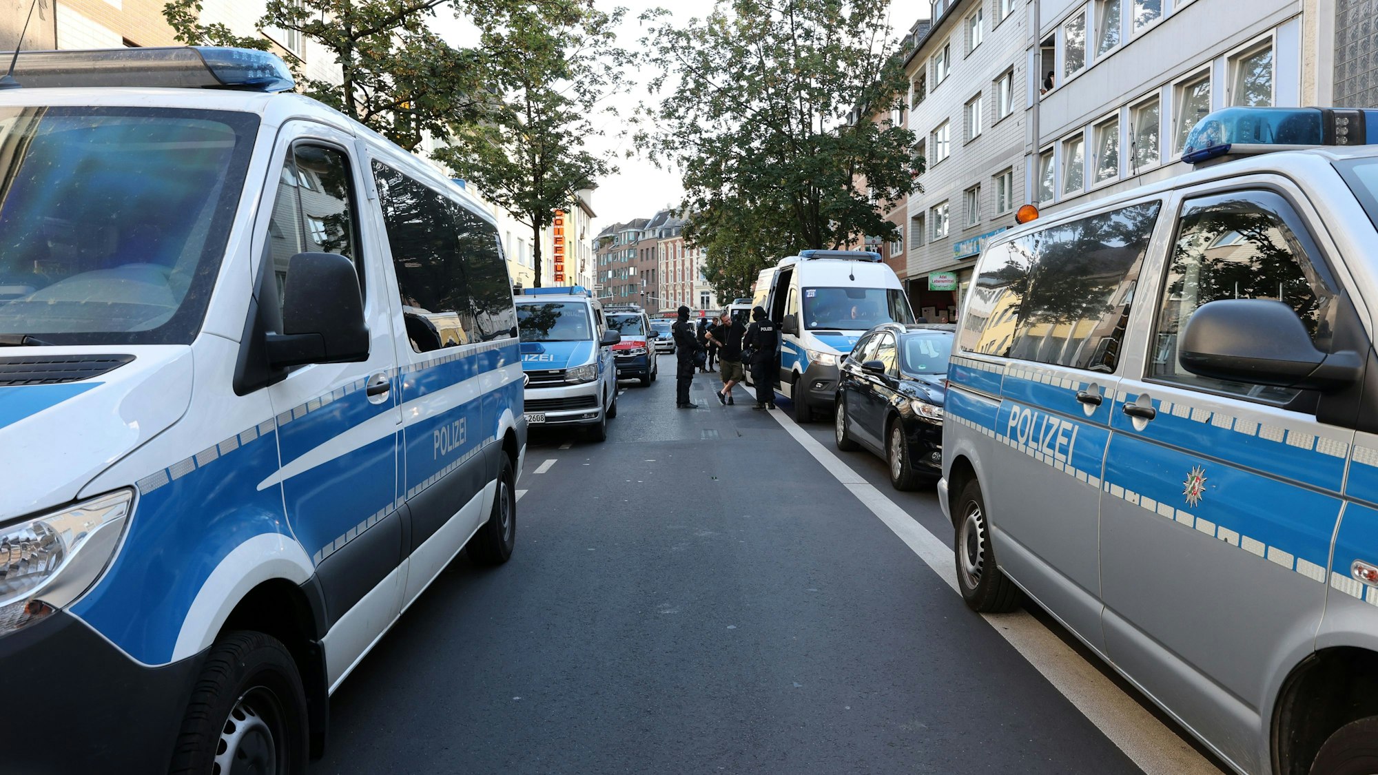 Einsatzfahrzeuge der Polizei stehen auf einer Straße in Kalk.