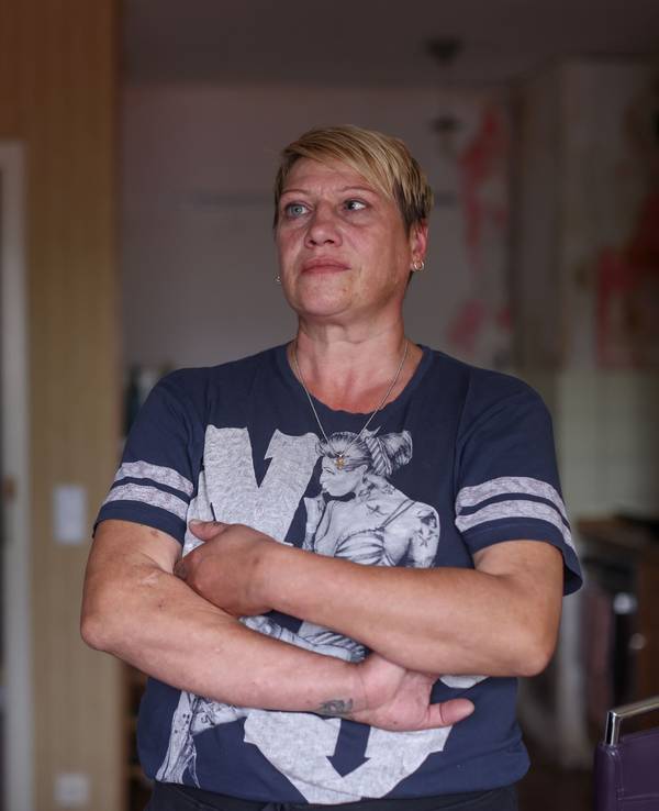Angela Aranov steht mit verschränkten Armen in ihrer Wohnung.