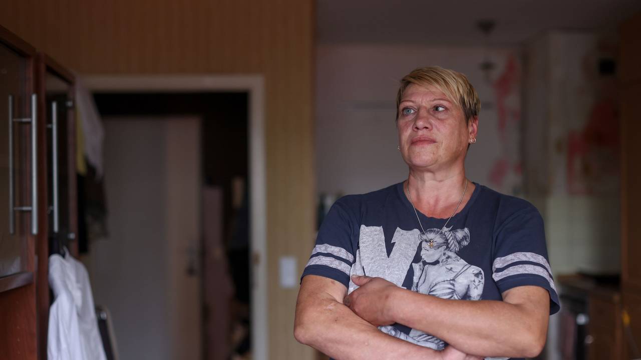 Angela Aranov steht mit verschränkten Armen in ihrer Wohnung.