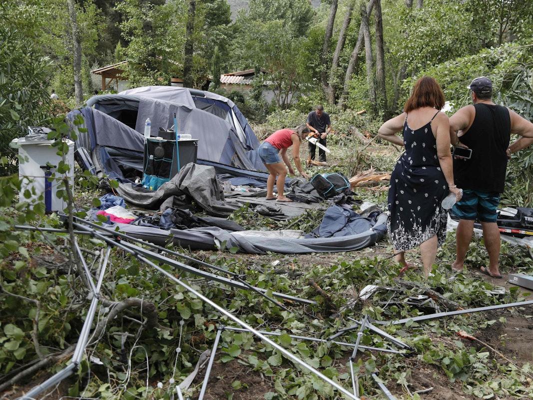 Camper packen die Reste ihrer zerstörten Zelte und anderen Gegenstände auf dem Campingplatz Sagone ein, wo ein Baum während der Stürme auf der französischen Mittelmeerinsel Korsika auf einen Bungalow gestürzt ist. Bei heftigen Unwettern sind im Mittelmeerraum und in Österreich mehrere Menschen getötet worden. Auf der französischen Mittelmeerinsel Korsika kamen gestern einige Menschen ums Leben.