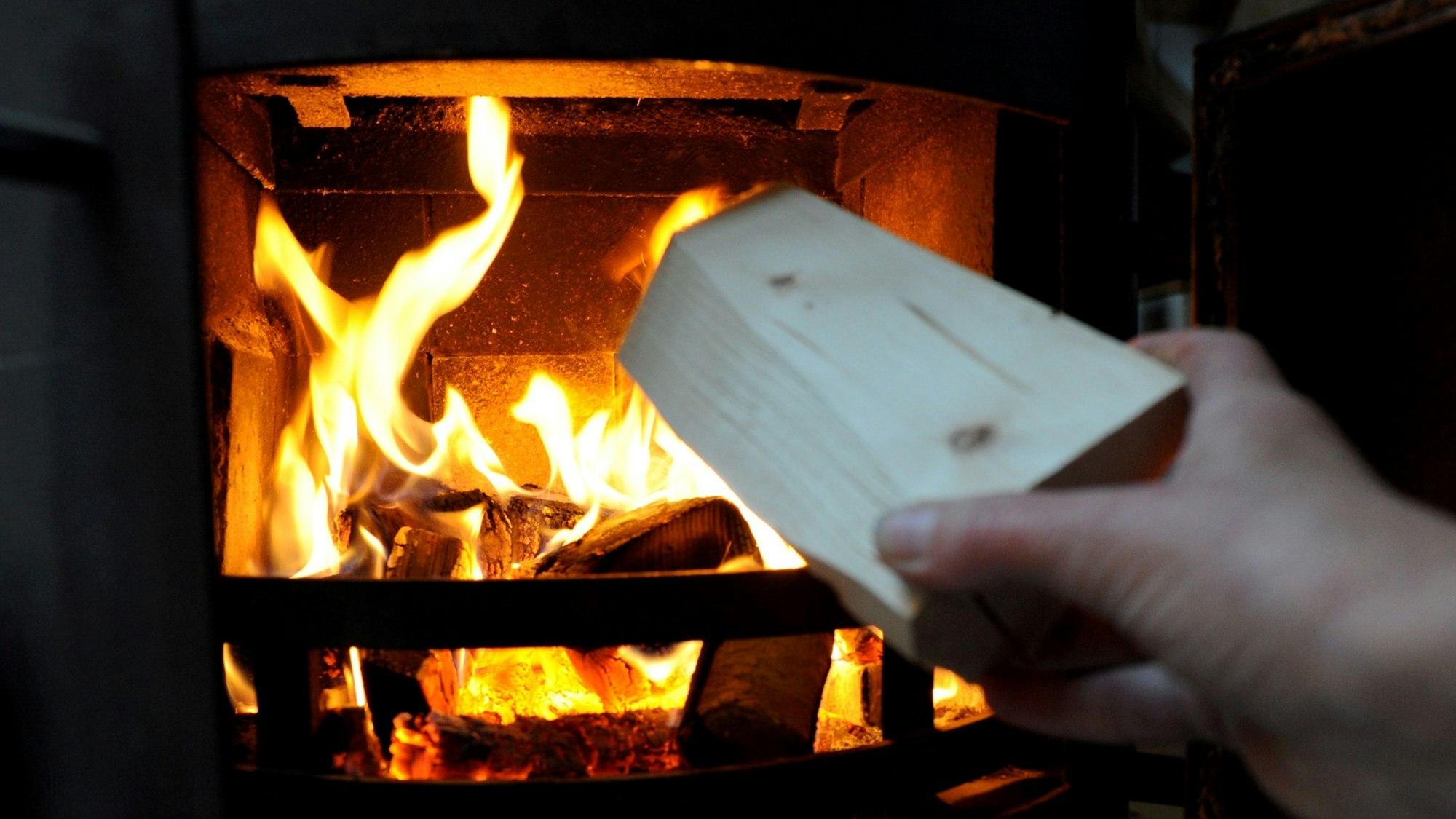 Eine Frau heizt im Januar 2010 in Passau (Niederbayern) einen Holzofen ein.