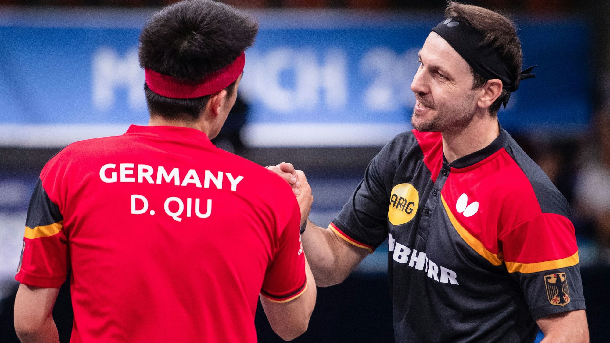 Die deutschen Tischtennis-Spieler Timo Boll und Dang Qiu klatschen sich nach der Partie bei der EM in München ab.