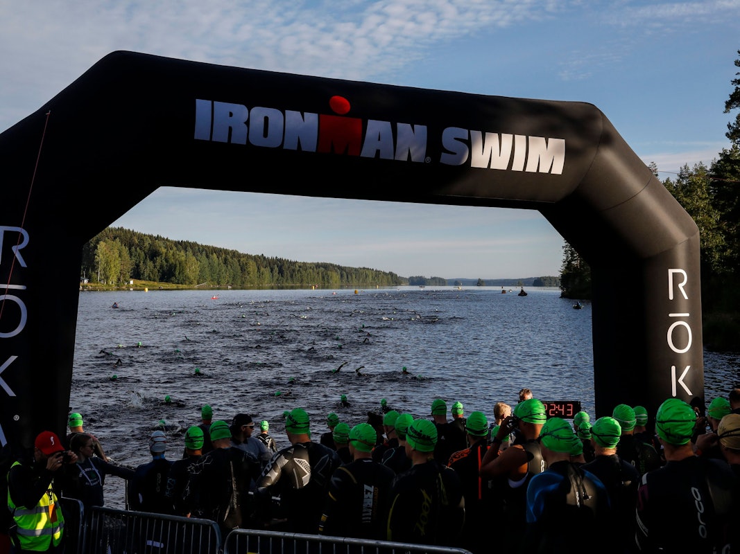 Triathletinnen und Triathleten gehen beim Ironman in Finnland ins Wasser.