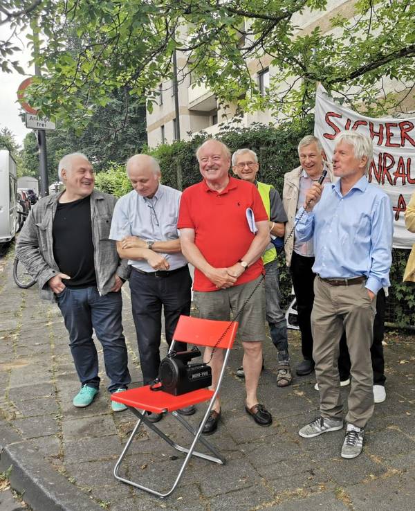 Eine Gruppe von Männern steht bei einer Mahnwache zusammen.