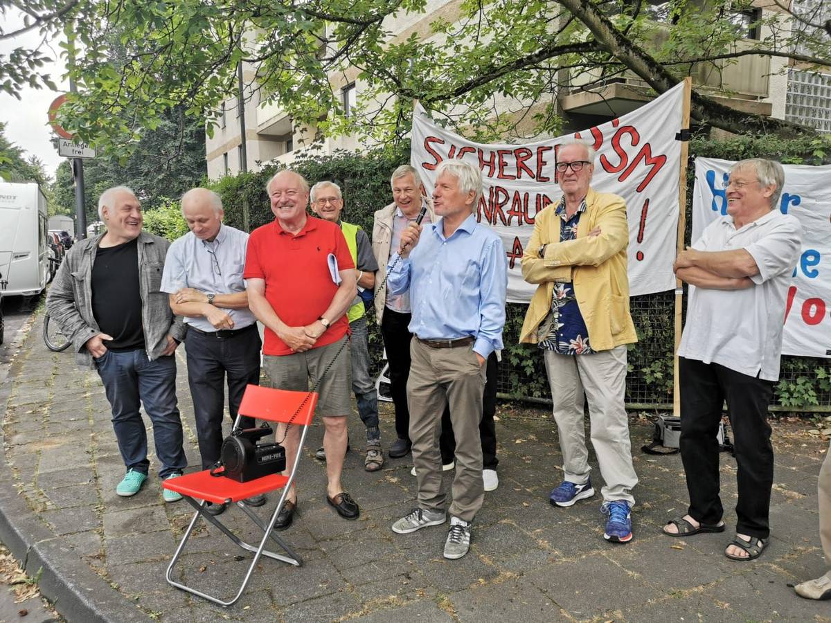 Eine Gruppe von Männern steht bei einer Mahnwache zusammen.