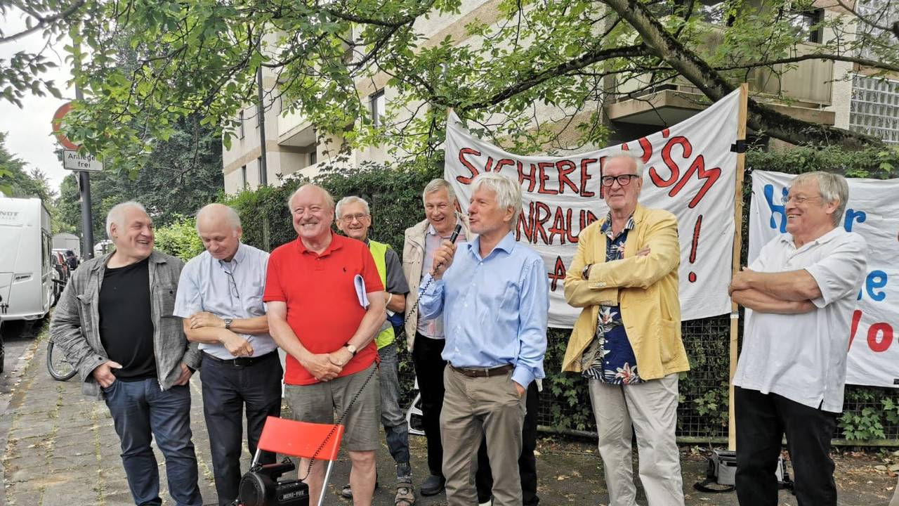 Eine Gruppe von Männern steht bei einer Mahnwache zusammen.