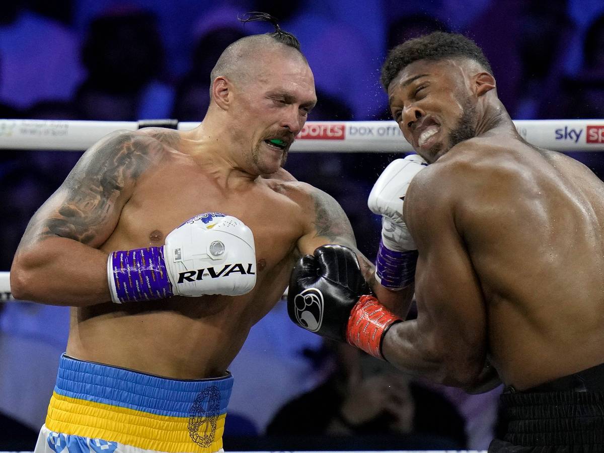 Anthony Joshua (r) muss einen Schlag von Oleksandr Usyk einstecken.