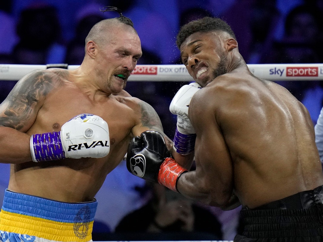 Anthony Joshua (r) muss einen Schlag von Oleksandr Usyk einstecken.