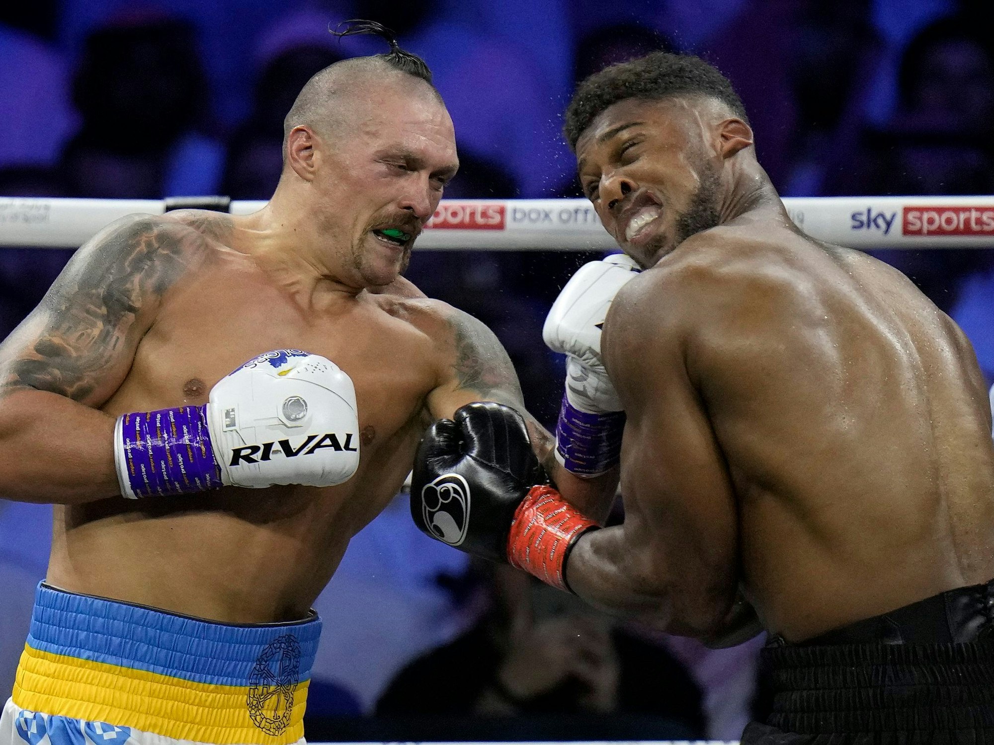 Anthony Joshua (r) muss einen Schlag von Oleksandr Usyk einstecken.