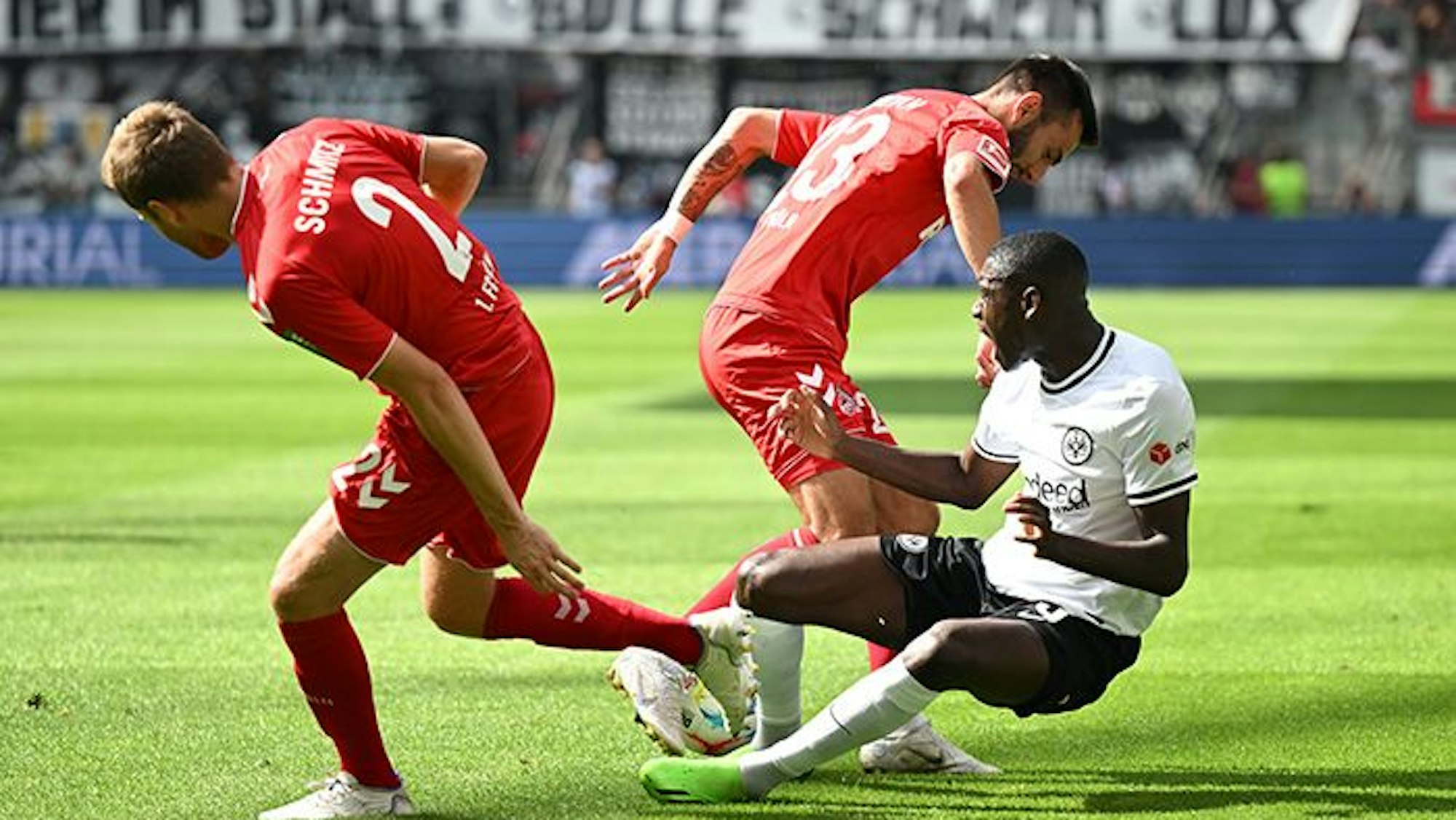 Die Kölner Benno Schmitz und Sargis Adamyan kämpfen mit Frankfurts Randal Kolo Muani um den Ball.