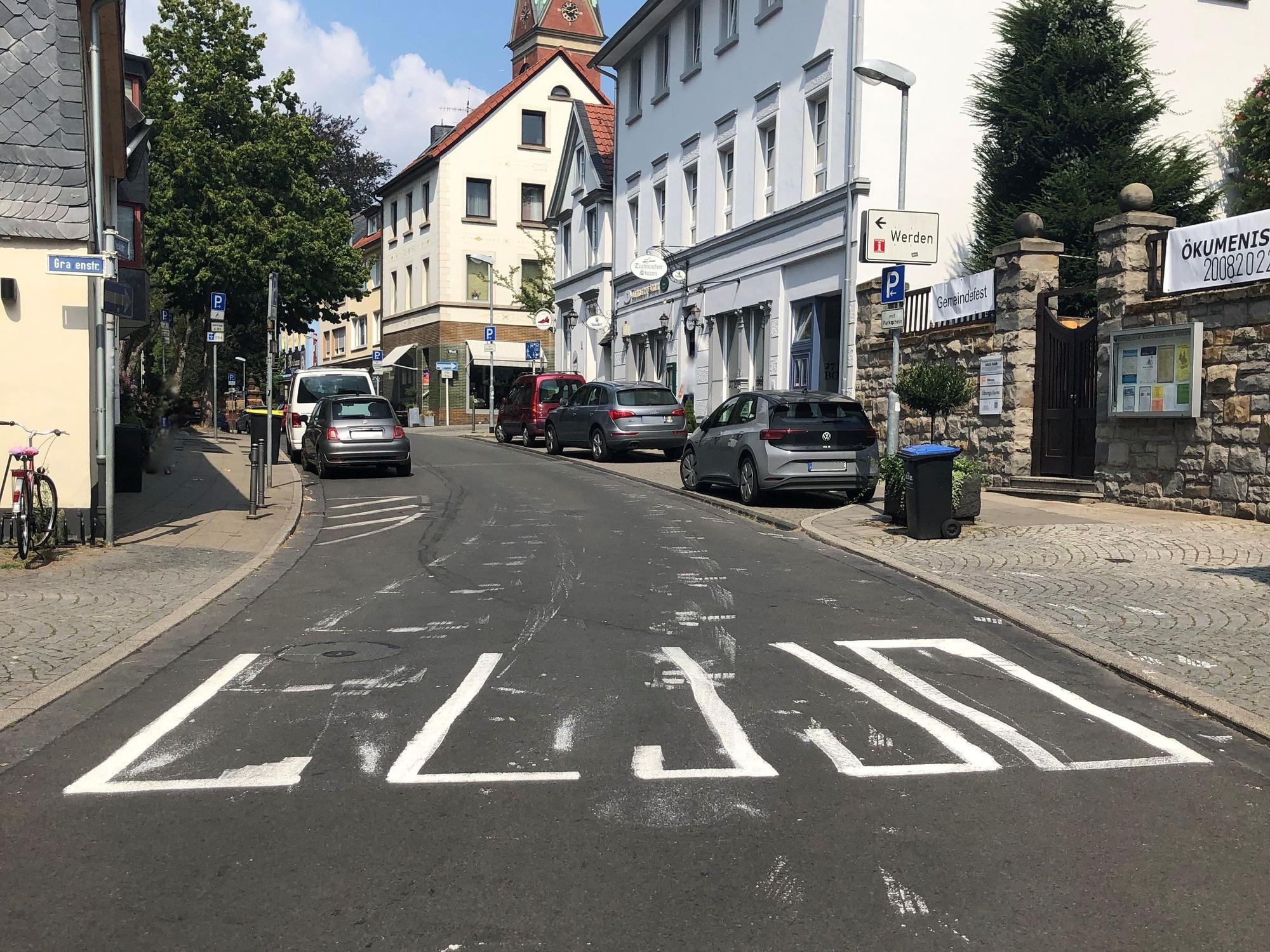 Ein aufgemalter Zebrastreifen auf einer Straße ist halb fertig.