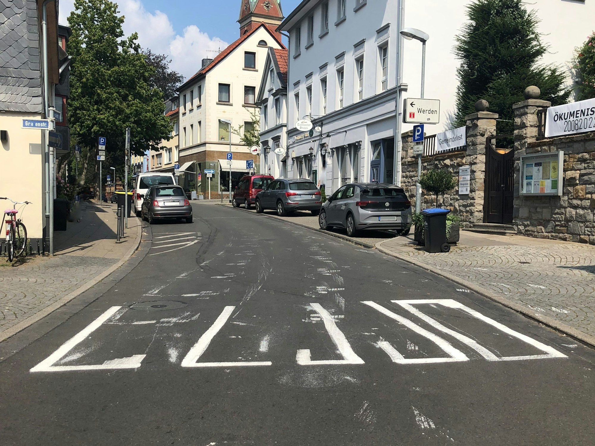 Ein aufgemalter Zebrastreifen auf einer Straße ist halb fertig.