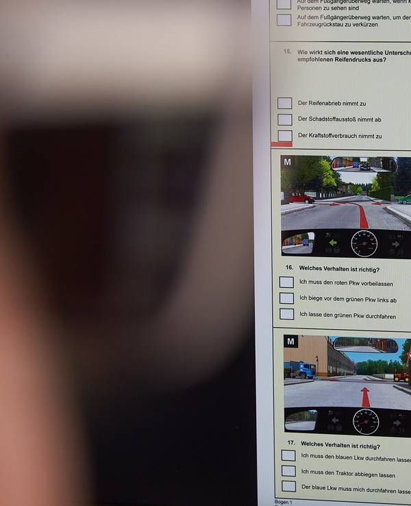 Ein junger Mann füllt am Computer einen Bogen zur Führerscheinprüfung aus (gestellte Szene).