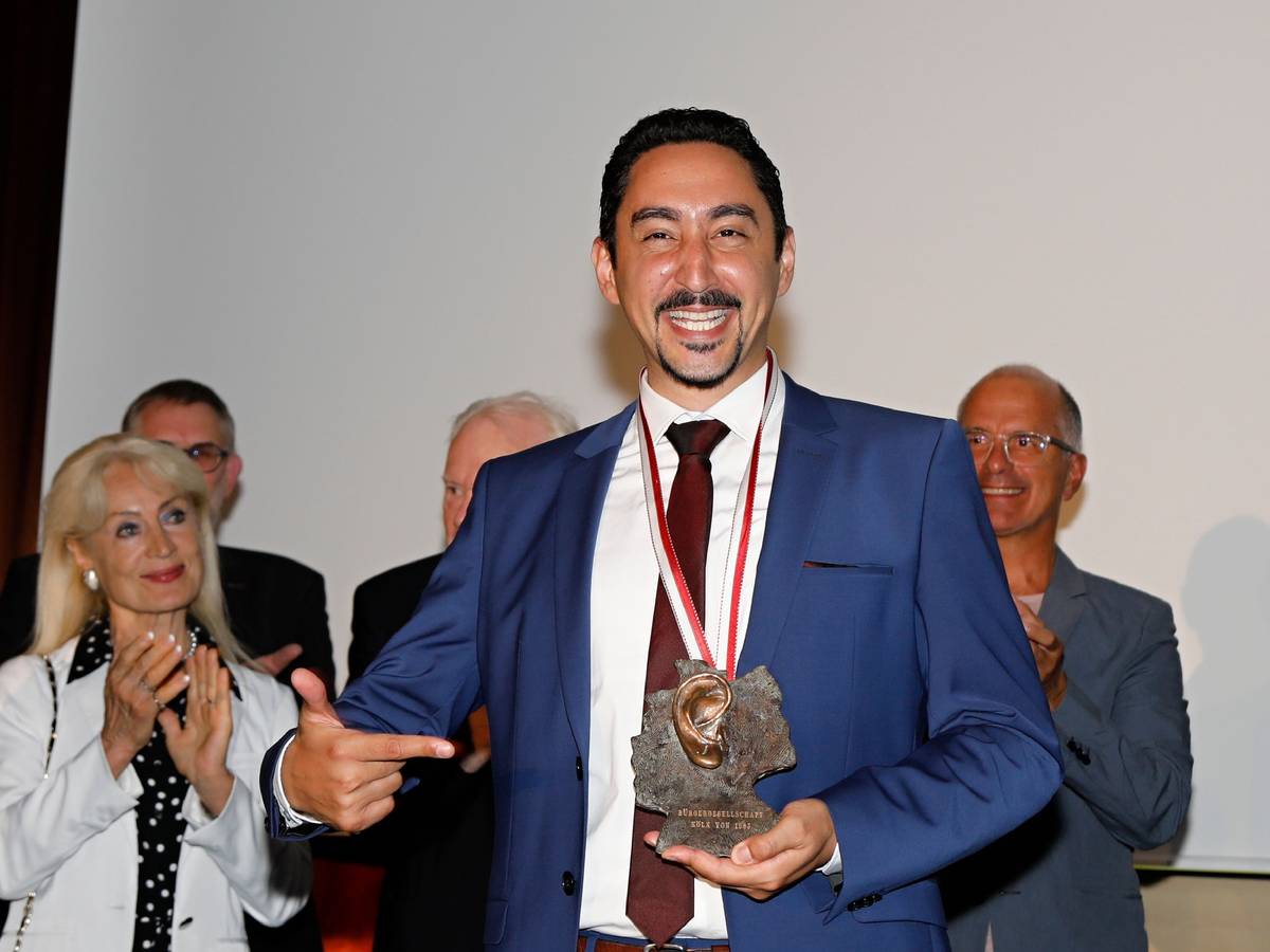 Rapper Eko Fresh hält einen Orden als Auszeichnung in der Hand.
