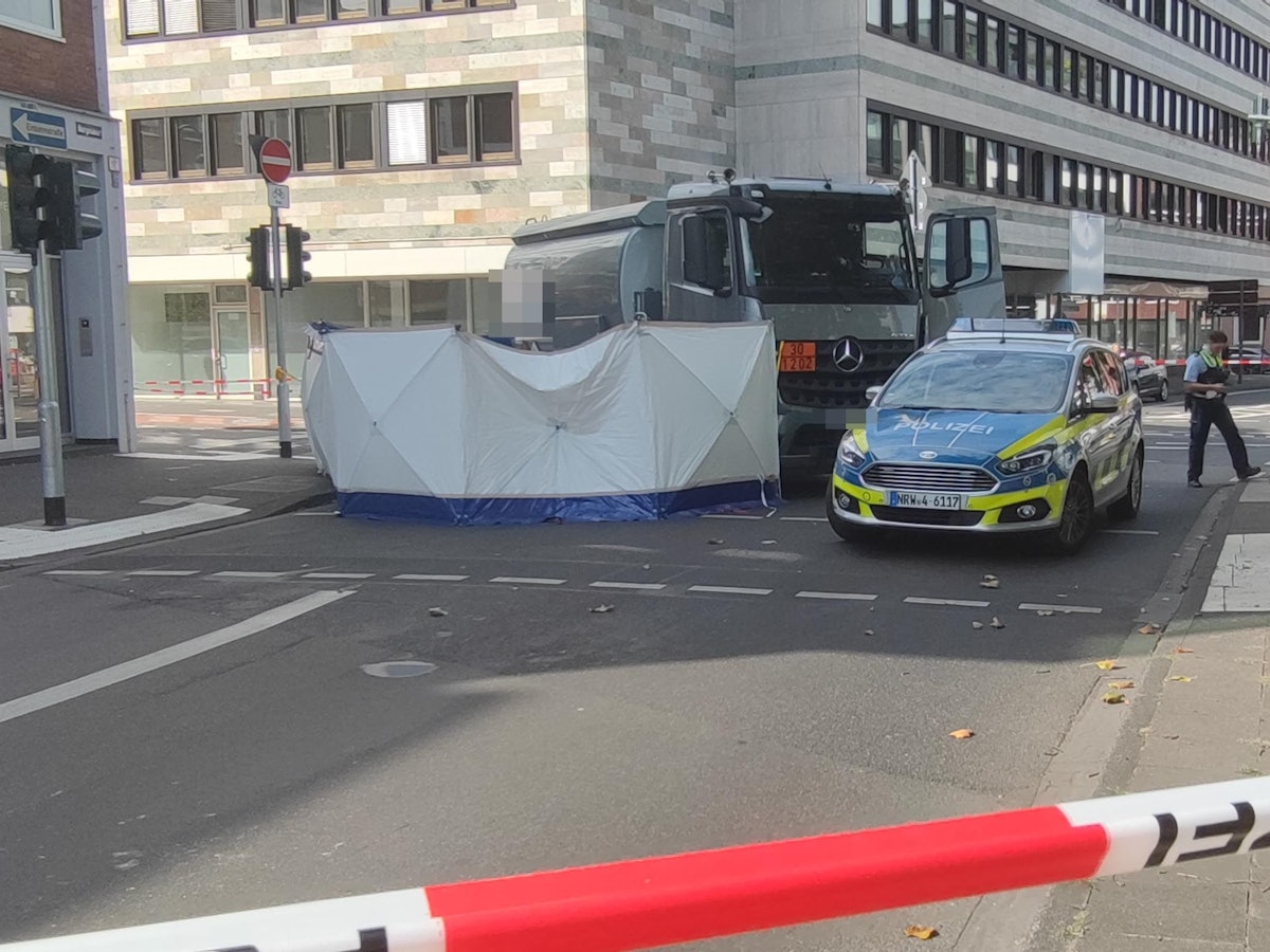 In der Kölner Altstadt wurde eine Fahrradfahrerin von einem Lastwagen erfasst. Die Polizei sperrt den Unfallort ab.
