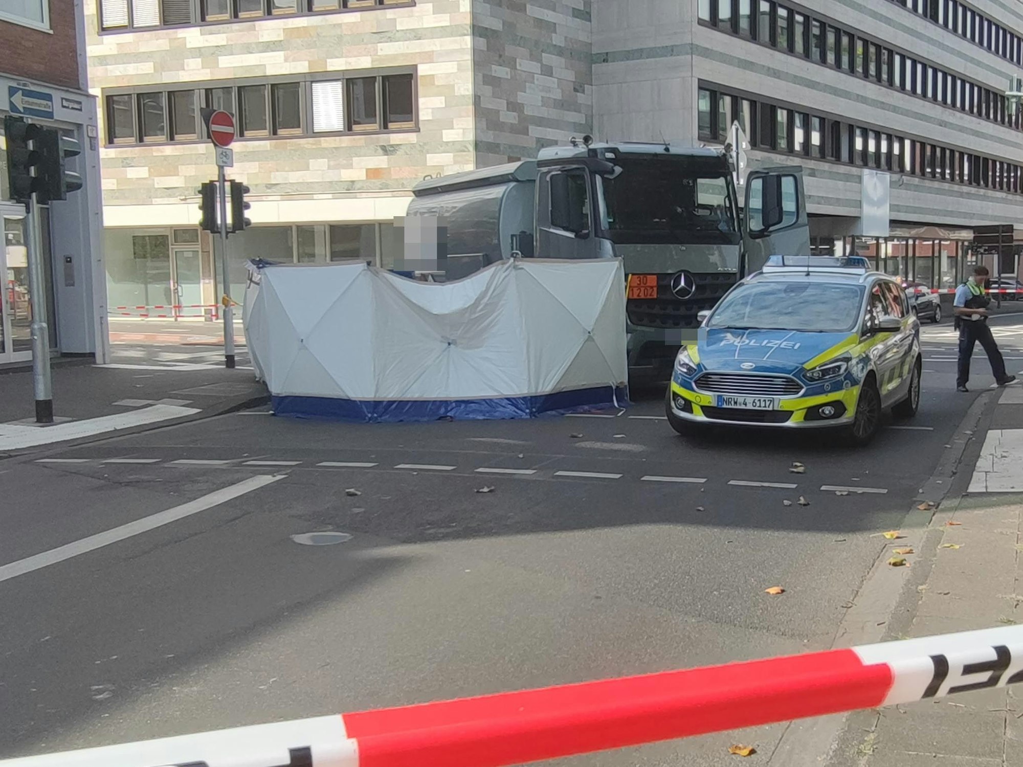 In der Kölner Altstadt wurde eine Fahrradfahrerin von einem Lastwagen erfasst. Die Polizei sperrt den Unfallort ab.