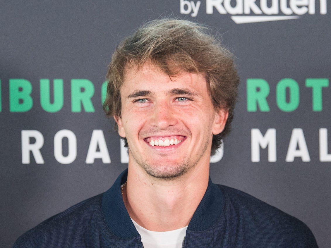 Alexander Zverev lächelt in die Kamera.
