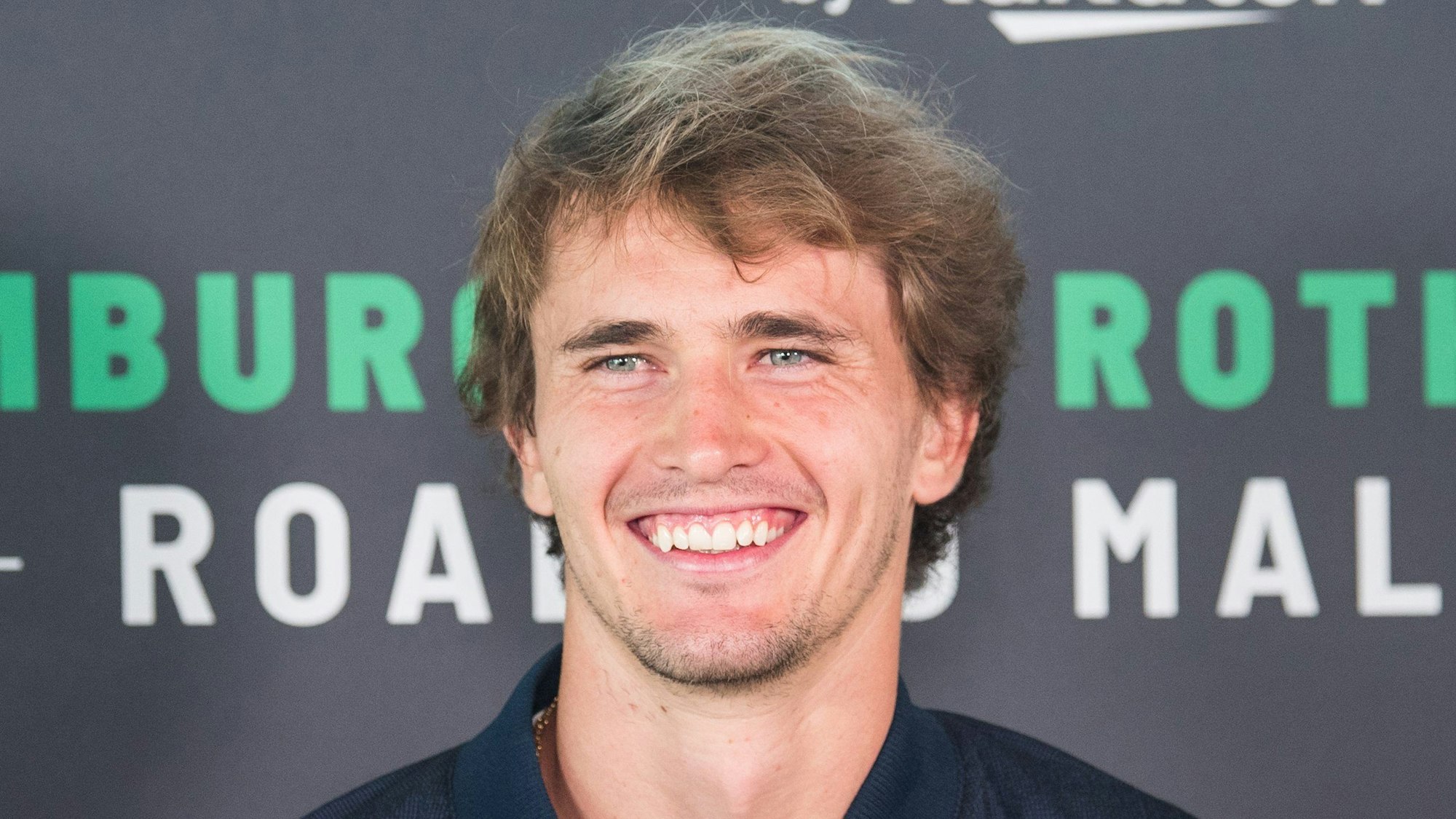 Alexander Zverev lächelt in die Kamera.