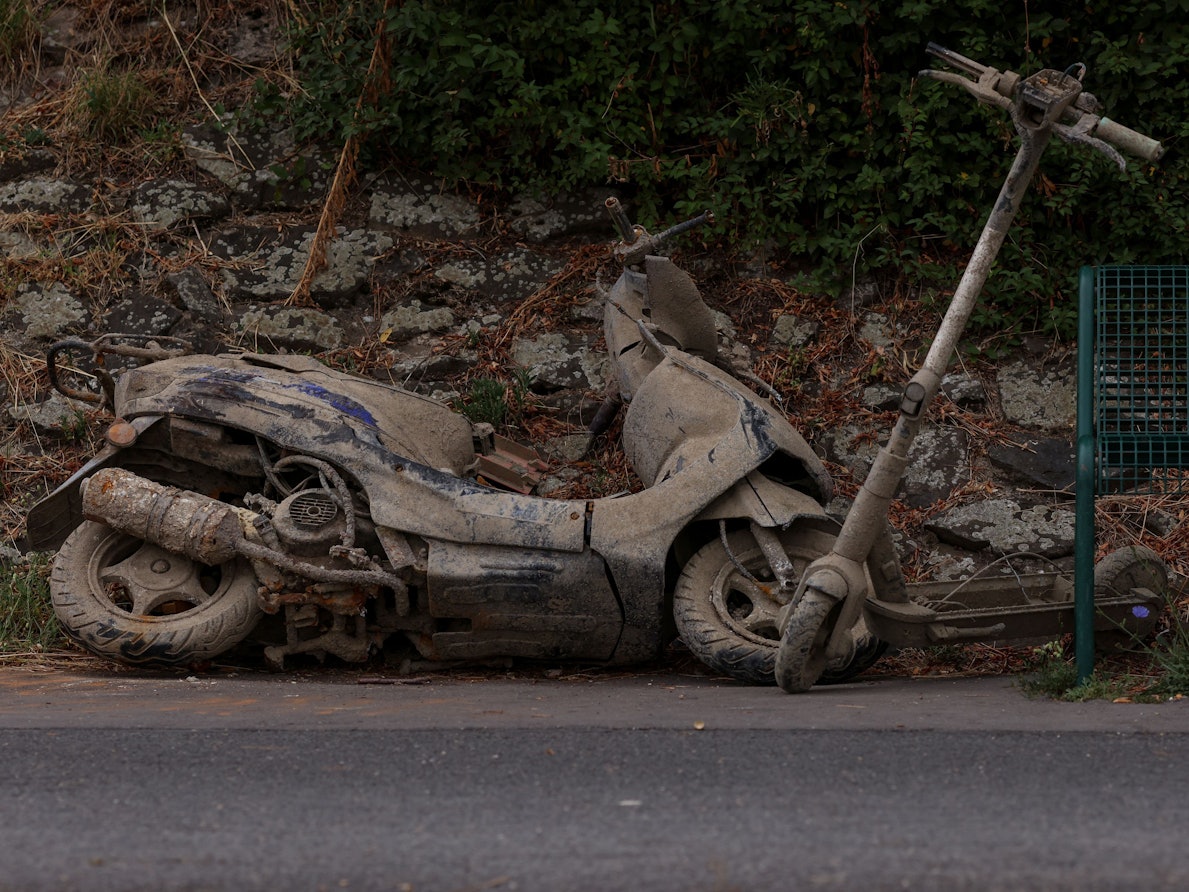 Ein Motorroller und ein E-Scooter liegen am Ufer in Köln-Stammheim.